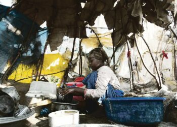 Somalityttö pesee astioita pakolaisleirillä Mogadishun ulkopuolella. YK:n mukaan 96 000 somalialaista on paennut toukokuussa uudelleen kiihtyneitä taisteluja.