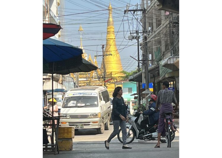 Mae Sotin vilkkaan valtaväylän ylle nousee buddhalaisen pagodin torni. Mae Sot on myanmarilaisten pakolaisten keskuspaikkoja.