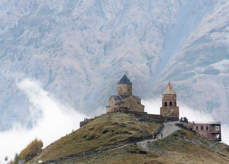 Tsminda Sameba eli Pyhän Kolminaisuuden kirkko vuoren jyrkänteellä Stepantsmindan kylän vieressä Kazbegissa.