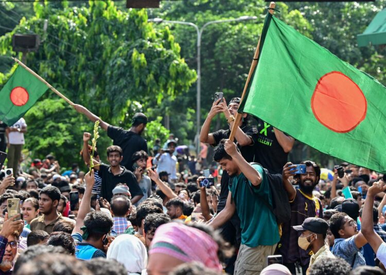 Mielenosoittajat juhlivat Bangladeshin pääkaupungissa Dhakassa maanantaina.