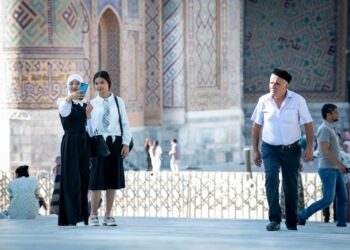 Turisteja ja paikallisia uzbekistanilaisia kuuluisalla Registanin aukiolla Samarkandissa.